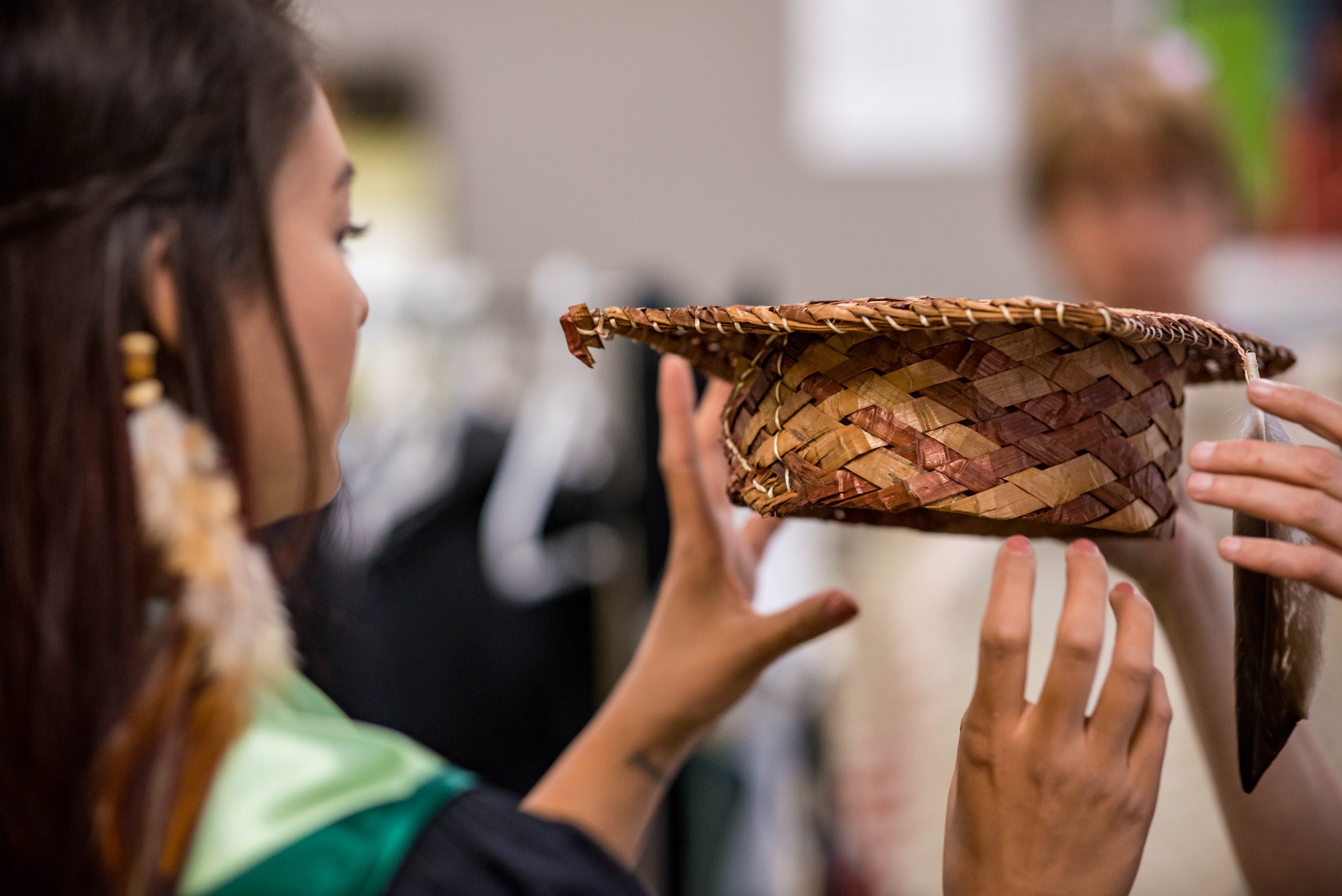 Indigenous Woman receiving a woven hat during graduation ceremony.