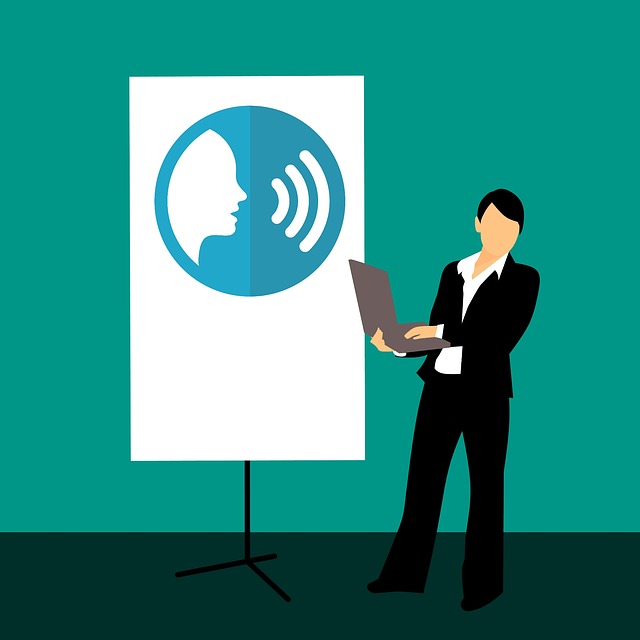 Person with laptop standing in front of a poster with image of person speaking