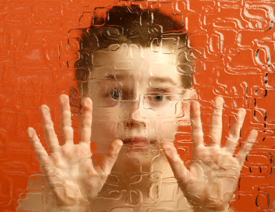 Photo showing a child looking through wavy glass at viewer