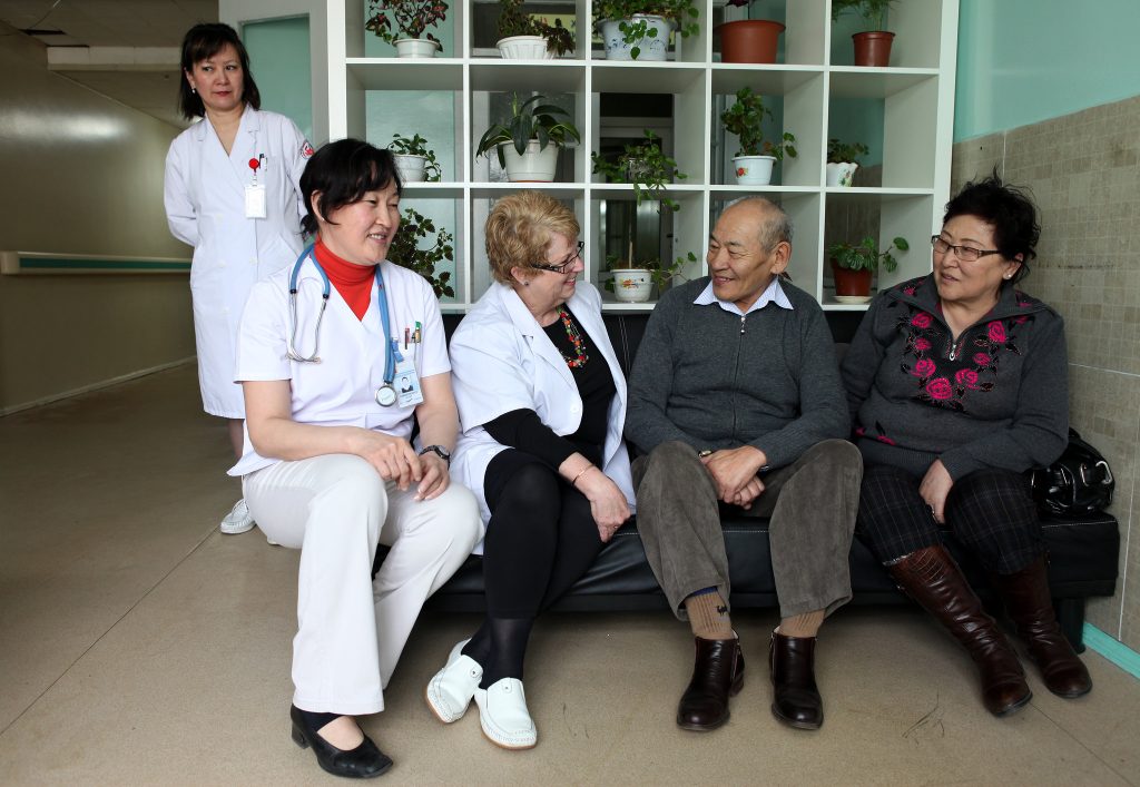 Photo showing five people engaged in a support group for caregivers