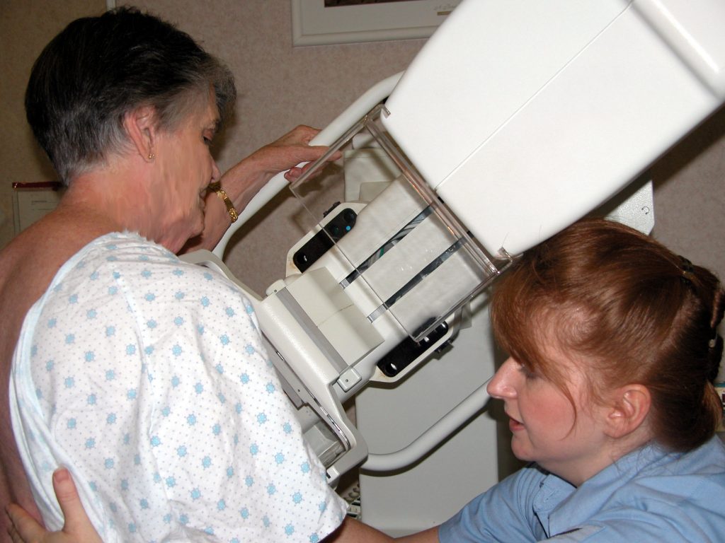 Photo showing a technician adjusting a patient for their mammogram