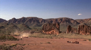 Screen snip of panoramic scene with a downward camera angle overlooking the first time the Irish workers, the British soldiers, and Quigley