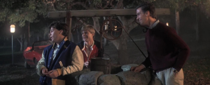 A group of boys standing next to a wishing well