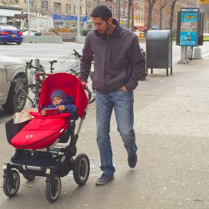 Man pushing a child in a stroller.