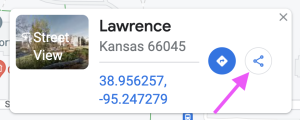 A screen capture image of Google Maps displays a Street View of Lawrence as an example place. There is a 'Share' icon, and a magenta-colored arrow is pointing to this icon to guide readers to click on it.