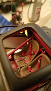 Close-up of a model car interior showing racing style bucket seats with five-point nylon harness style seat belts and roll cage.