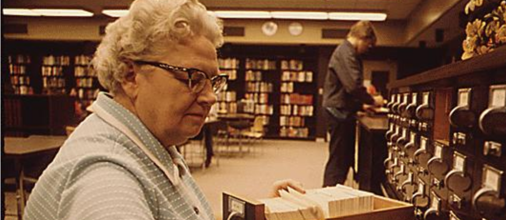 older female librarian sorting a cart catalog